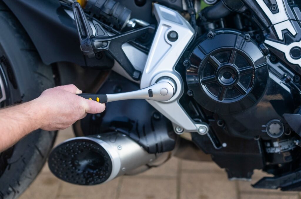 A service worker repairing a motorcycle at the service center