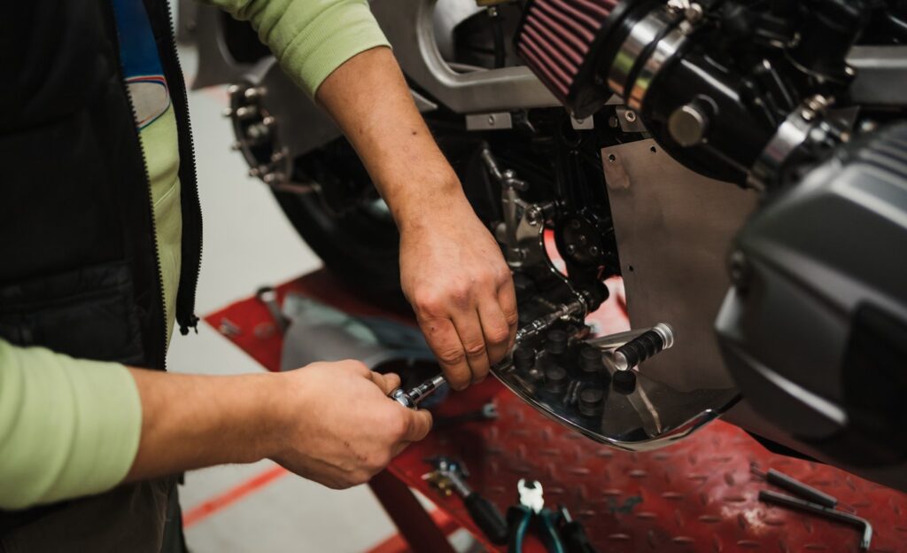 Man fixing a motorcycle in a modern workshop